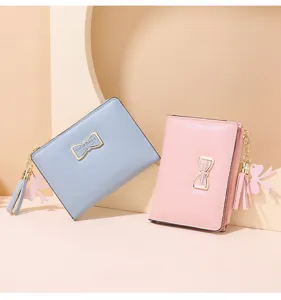 Detailed view of short women wallets in pastel blue and pink with cute bow pendants.