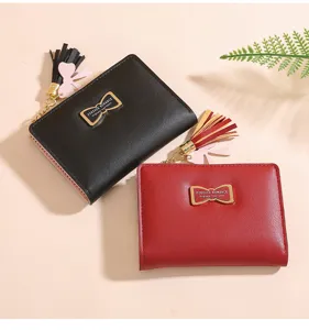 Short women's wallet PU leather coin purse with bow metal hardware and tassel charm.