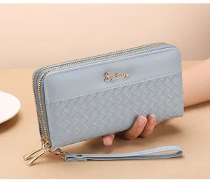 Close up of light blue long woven zip wallet with wrist strap and double compartment design.