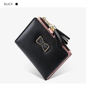 Black short wallet for women with pink interior, chic tassel pendant and metal bow decoration.