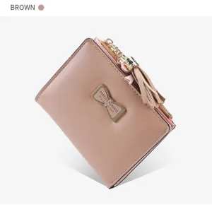 Detail view of brown short women wallet featuring metal bow plate and tassel zipper pull.