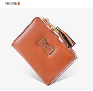 Detailed view of orange short women wallet with cute bow metal plate and stylish tassel zipper.