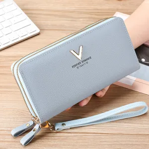 Detailed view of light blue leather long wallet, double zipper design and convenient wrist strap.