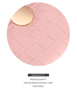 Pink wallet detail showing crocodile pattern leather and gold round snap button close up