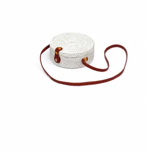 White round rattan woven crossbody bag with brown leather strap, compact and stylish summer purse.