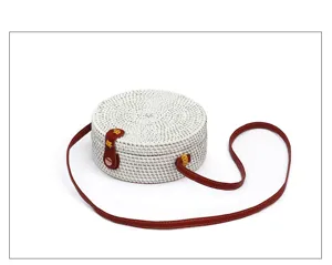 Detailed close-up of the white woven round rattan crossbody bag with elegant brown leather strap.