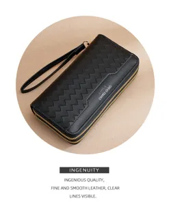 Detail view of black long wallet with chevron pattern, double zipper and wrist strap.