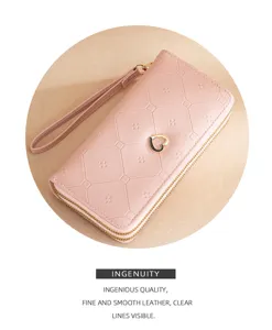 Pink long double zipper wallet with wrist strap and heart charm, clear geometric embossed texture.