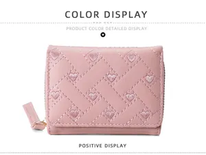 Pink short quilted wallet for women with cute heart embroidery and zipper pull design.