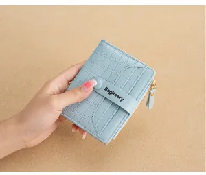 Close-up detail of light blue crocodile pattern bi-fold wallet with card slots and zipper.