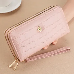 Close-up view of pink double zipper long wallet featuring chic metallic clasp and wrist strap.