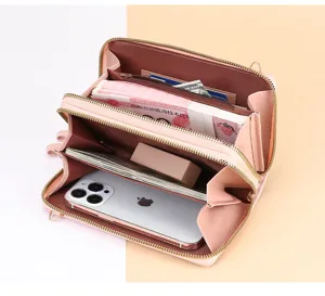 Vue détaillée du portefeuille rose à double fermeture éclair montrant la grande capacité intérieure.