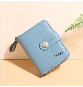 Close-up view of a light blue short wallet with a snap button and zipper pocket.