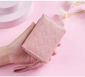 Pink quilted heart embroidered short wallet, PU leather card holder with wrist strap detail.
