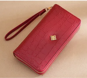 Detail shot of red crocodile pattern women long wallet with double zipper and wrist strap.