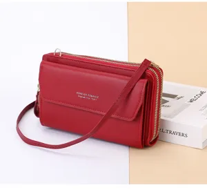 Vue détaillée du sac bandoulière rouge à double fermeture éclair et texture en cuir.