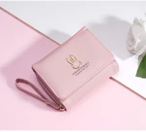 Roze korte drievoudig gevouwen damesportemonnee met schattig konijnen metalen badge en polsband.