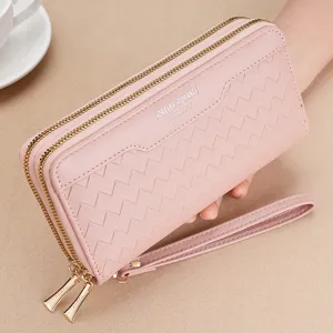 Pink women's long wallet double zipper PU leather clutch purse with wrist strap and chevron pattern.