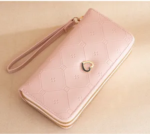 Women pink long double zipper wallet large capacity clutch bag with wrist strap and heart decor.