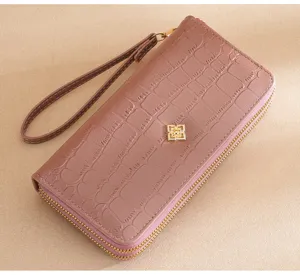Detail shot of women long wallet, double zipper clutch purse with croc pattern and wrist strap.