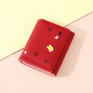 Detail view of a stylish red short women wallet featuring butterfly print and metal decor.