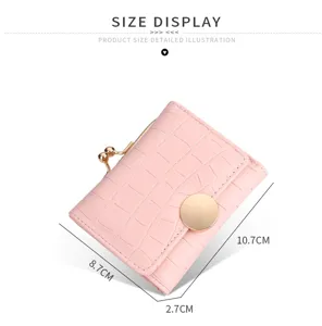 Pink short wallet detail showing compact size, metal kiss lock clasp and croc pattern leather.