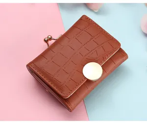Detailed view of the short brown wallet, showing crocodile texture, kiss-lock and metal snap.
