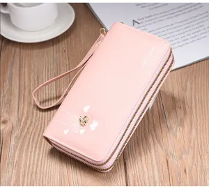 Monedero largo rosa para mujer con doble cremallera, correa de muñeca y elegante dije de corazón.
