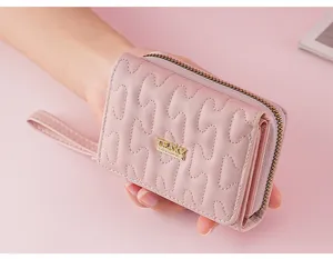 Rosa gestepptes Kurzportemonnaie mit Reißverschluss, Kartenfächern und Handschlaufe für Damen.