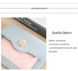 Gros plan sur le portefeuille court pour femme en PU avec fermoir camélia et détail matelassé.