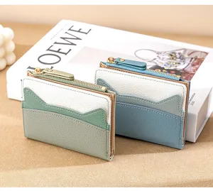 Detail shot of cute color-blocking mini card wallets with zipper and cat ear design features.