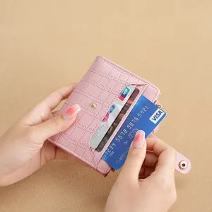 Women's short pink wallet with crocodile texture, multi-card slots and secure snap closure.