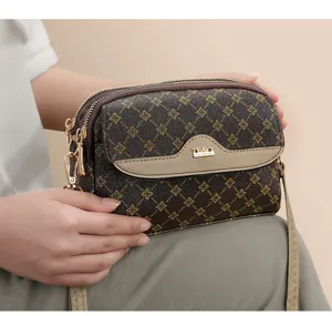 Women's vintage monogram crossbody bag with dual zipper compartments and chic flap design.