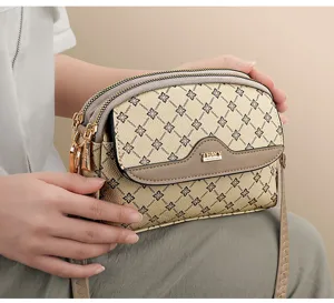 Women stylish monogram crossbody bag with multi-layer zippers and elegant shoulder strap.