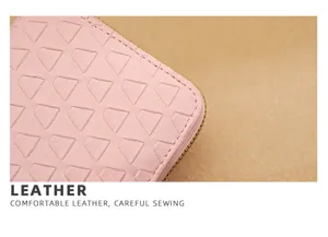 Roze lederen portemonnee detail textuur close up met gladde rits en geometrisch patroon.