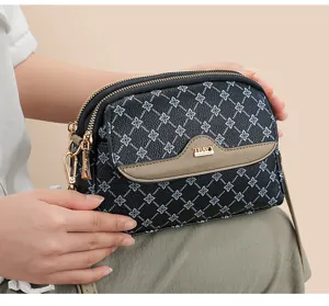 Stylish monogram crossbody bag with multi-compartment design, durable leather and gold hardware.