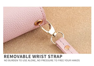 Close-up detail of pink leather wallet wrist strap with gold metal hardware clasp hook accessory.