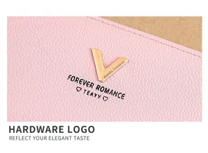 Close-up view of women's pink leather long wallet showcasing refined metal V logo and letter prints.