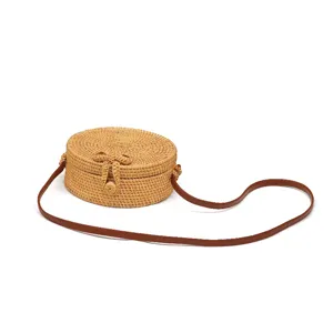 Ronde geweven rotan crossbody tas voor dames met lederen band en strikdetail vintage stijl.