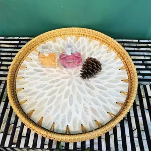 Handgemaakt rond geweven rattan en parelmoer dienblad voor fruit en snackdecoratie.