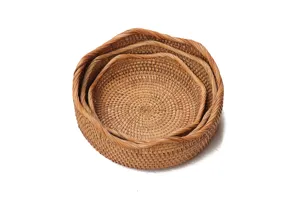 Panier de rangement rond en rotin naturel en detail, texture fine et design gigogne.