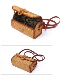 Gedetailleerd overzicht van de geweven rattan crossbody tas met patroon voering en leren band.