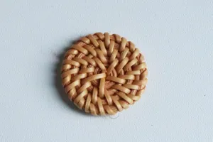 Close-up detail van een ronde geweven rattan knop, ideaal voor handgemaakte DIY oorbellen.