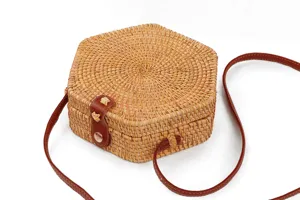 Natural rattan woven crossbody bag with hexagonal shape and brown leather strap details.