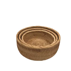 Set van ronde geweven rattan opbergmanden voor fruit en snacks op de salontafel.