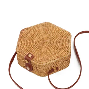 Handmade hexagonal rattan woven crossbody bag with brown leather strap and metal buckle.
