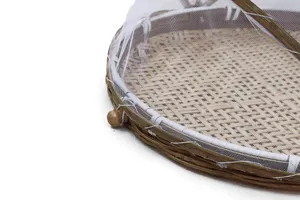 Cesta de bambú tejida con cubierta de red blanca en detalle para secar alimentos al sol.