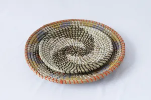 Vista di dettaglio del piatto decorativo in erba marina intrecciata con motivo a spirale.