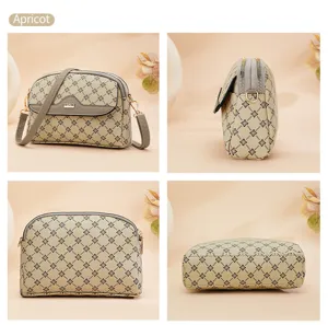Stylish apricot crossbody bag with vintage monogram pattern and dual zipper compartments.