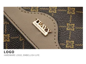 Detailed view of a stylish brown monogram women's crossbody bag with elegant metal hardware logo.